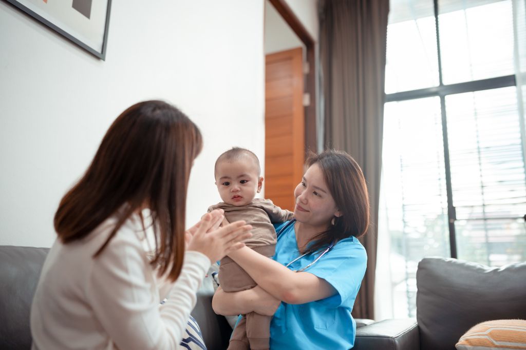 Caregiver from a nanny agency in Singapore interacting with a baby during home-based childcare support