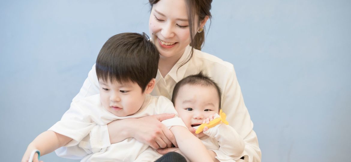 Caregiver support arranged by a confinement nanny agency in Singapore helping care for multiple young children at home