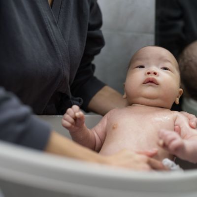 Confinement nanny in Singapore bathing a newborn baby, providing gentle hygiene care and professional postnatal support at home