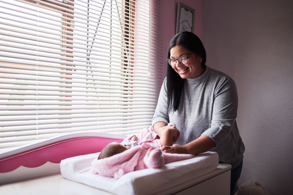 Newborn care routine supported by a confinement nanny agency in Singapore, with caregiver changing a baby safely at home