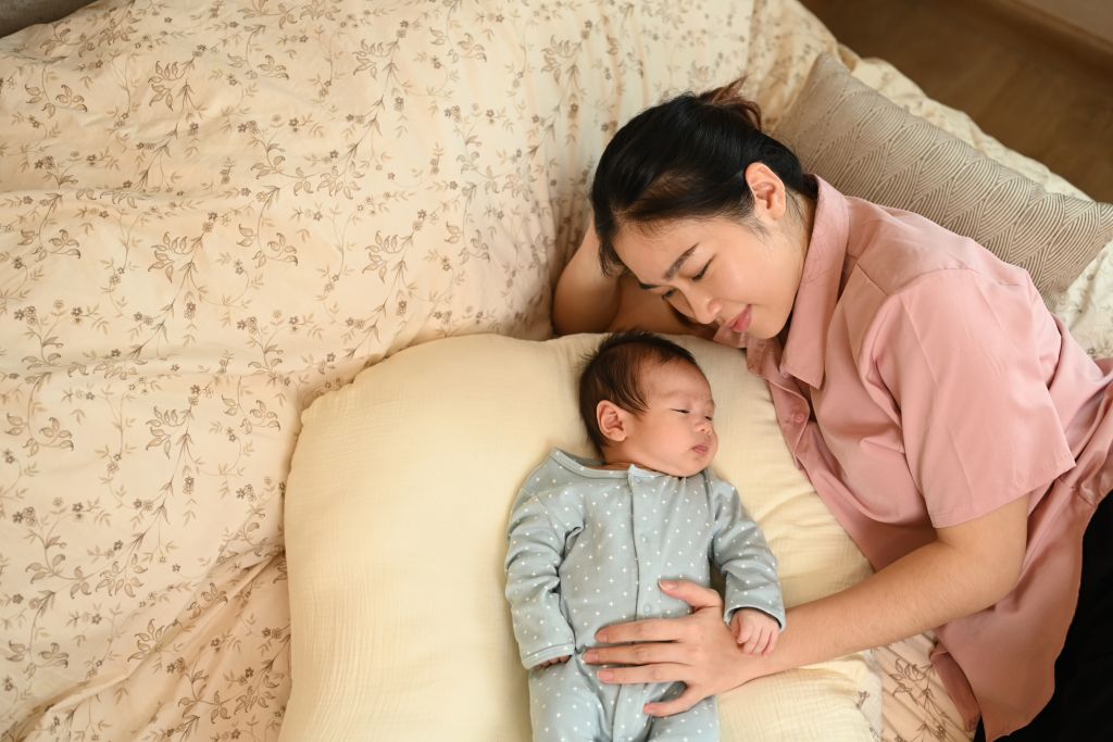 Newborn resting safely beside a mother with postnatal support arranged by a nanny agency in Singapore